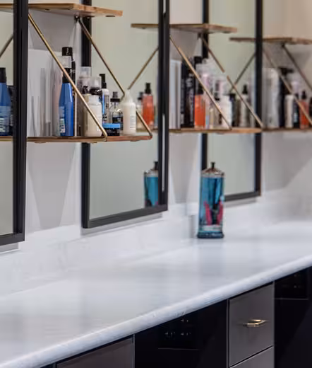 Hair styling stations and product shelves at Pedi & Mane