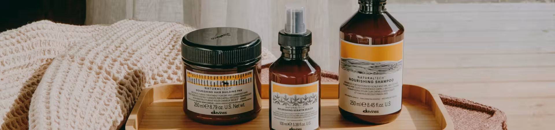 Davines hair care products on a wooden tray