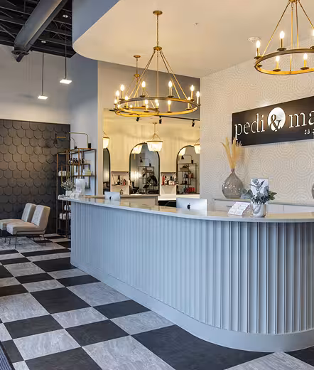 Front desk and lobby under gold chandeliers at Pedi & Mane
